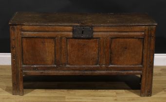 A late 17th century oak blanket chest, hinged top, three panel front, stile feet, V-shaped end