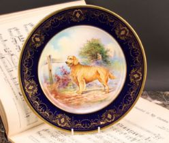 An Aynsley circular plate, painted by J. Shaw, signed to verso, with a Golden Retriever by a