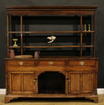 A George III oak dog kennel dresser, moulded cornice above a pair of plate racks flanked by open