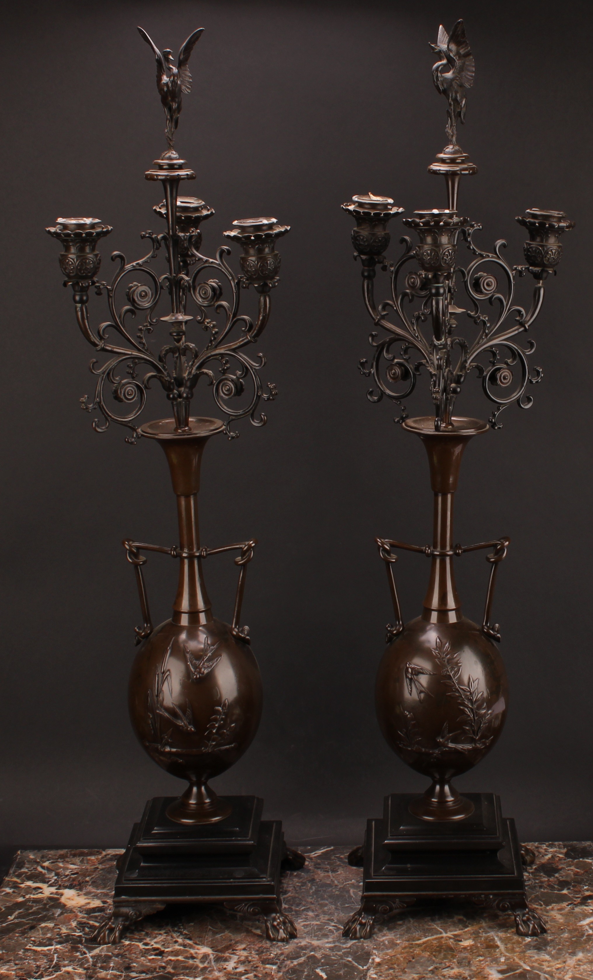 A pair of 19th century French brown patinated bronze table candelabra, stork finials, each vasular