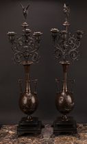 A pair of 19th century French brown patinated bronze table candelabra, stork finials, each vasular