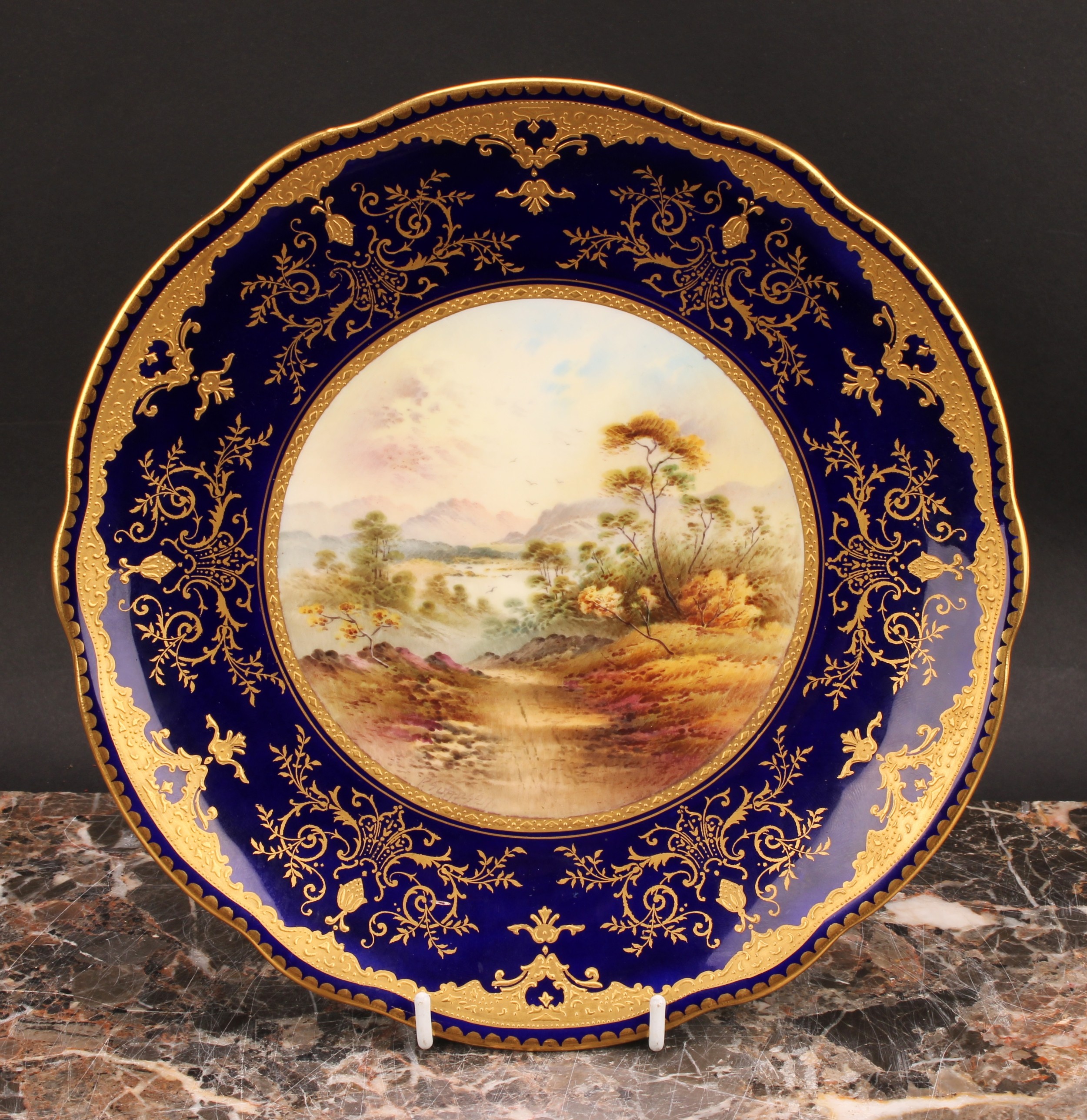 A Coalport Named View shaped circular plate, painted by P. Simpson, signed, In The Grampian Hills, - Bild 2 aus 6