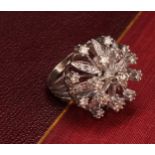 A large and impressive flowerhead diamond cluster ring, the central round brilliant cut stone within
