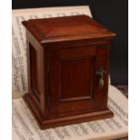 A Victorian oak table top cabinet, sarcophagus top above a panelled door enclosing three collector's