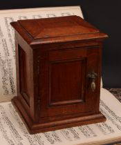 A Victorian oak table top cabinet, sarcophagus top above a panelled door enclosing three collector's
