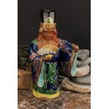 A Japanese porcelain figure, of an elder holding a fan, painted in polychrome and picked out in