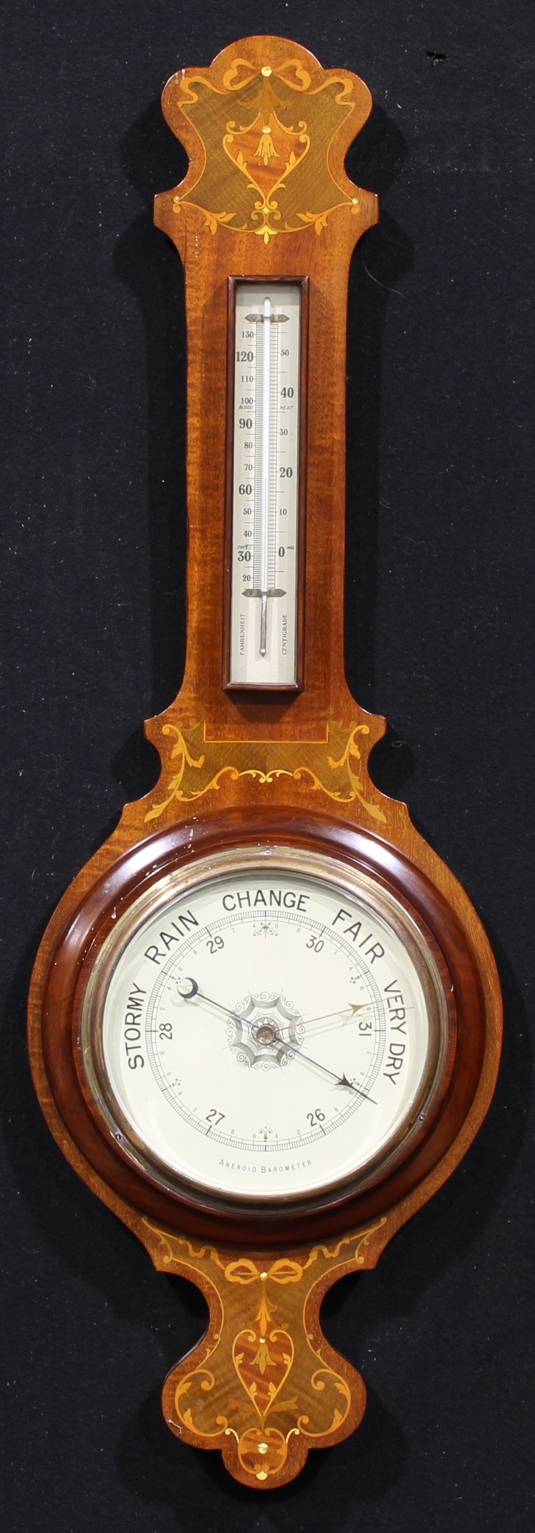 An Edwardian Sheraton Revival mahogany and marquetry wheel barometer, 19.5cm register, mercury