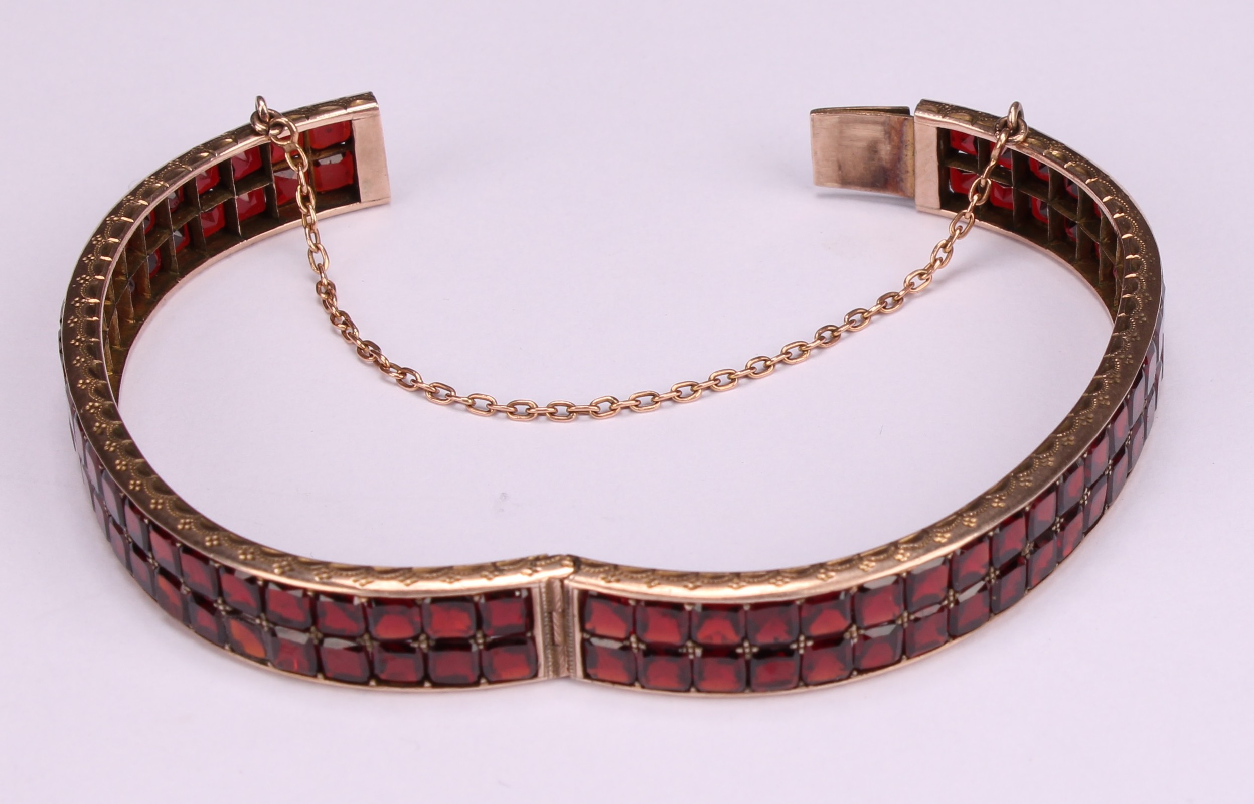 A continental gold bangle, applied with a double row of asscher cut channel set garnets, the - Image 3 of 5