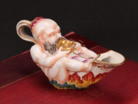 A Naples porcelain inkwell, shaped as an oil lamp, moulded with a Bacchanalian reveller, painted