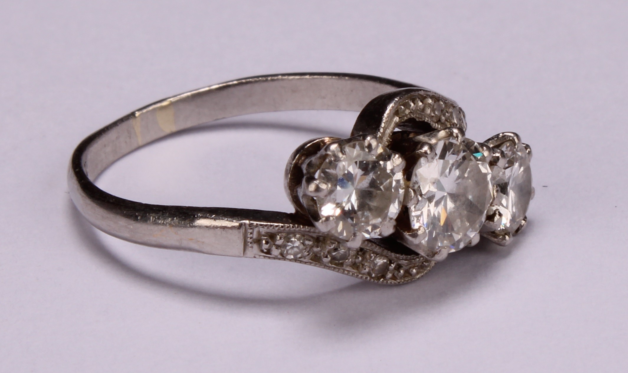 A diamond and platinum three stone twist ring, the central round brilliant cut stone flanked by - Image 2 of 4