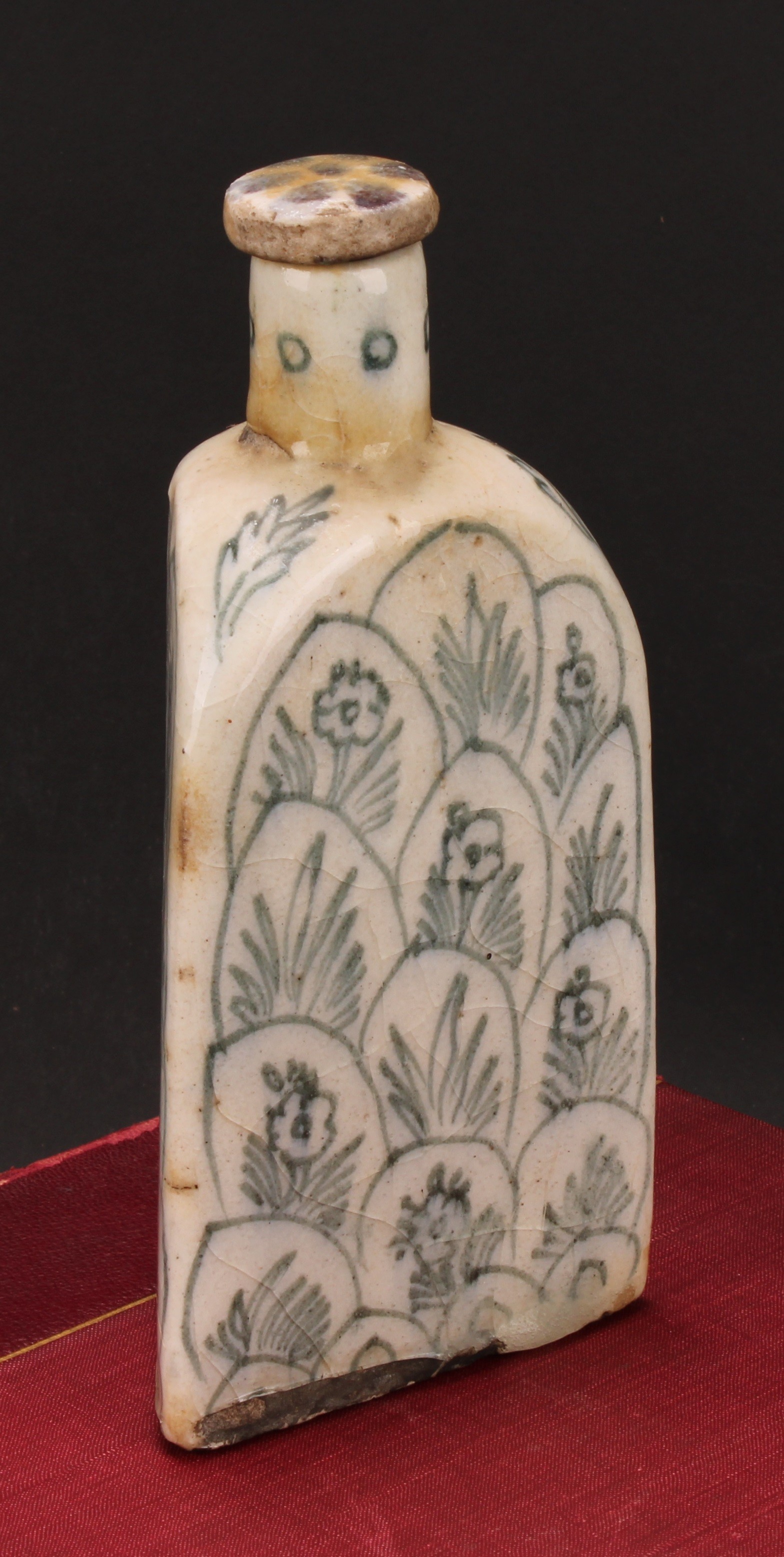 A Middle-Eastern tin-glazed earthenware triform flask, decorated with flowers and layered lotus,