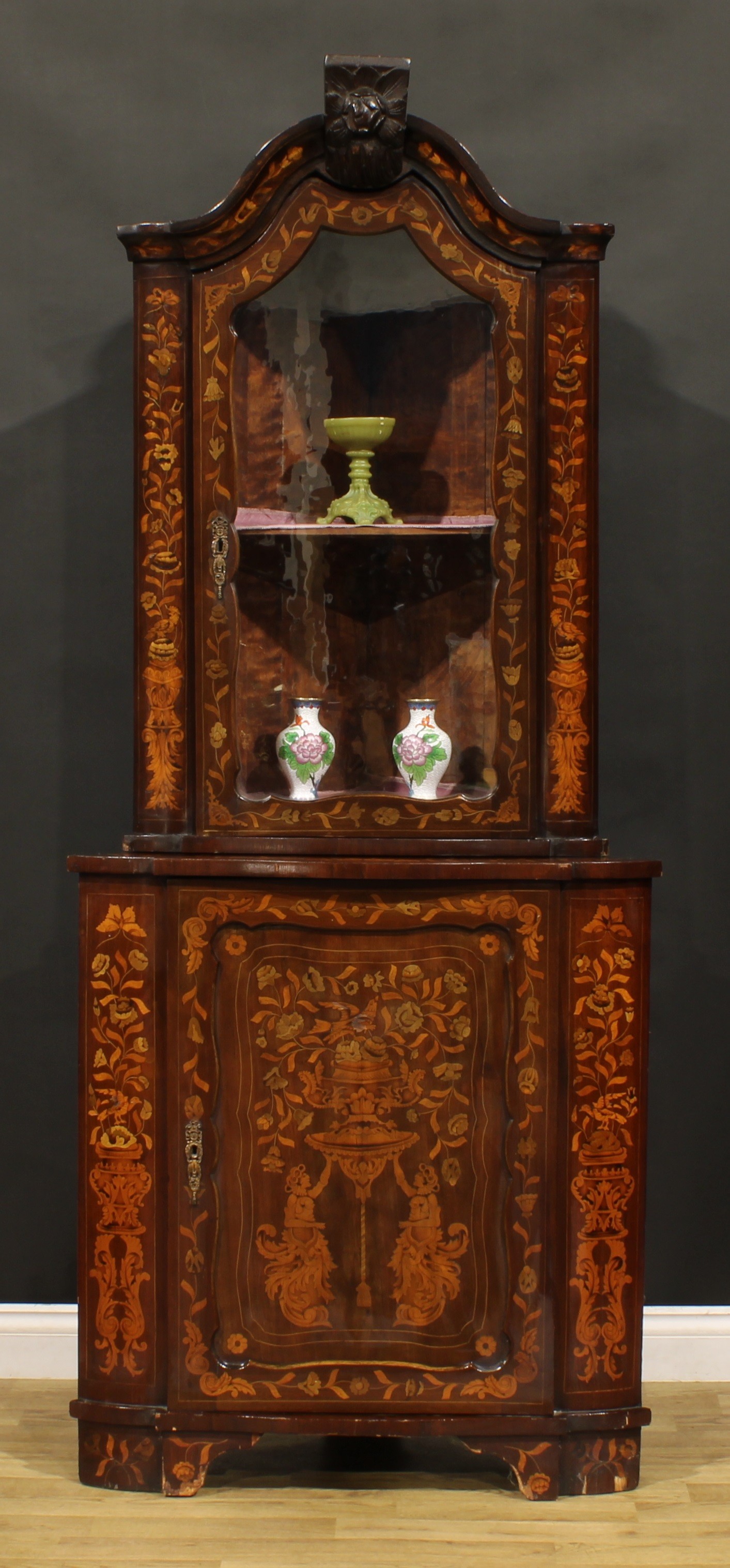 A 19th century Dutch marquetry floor standing corner display cabinet, arched cresting above a glazed