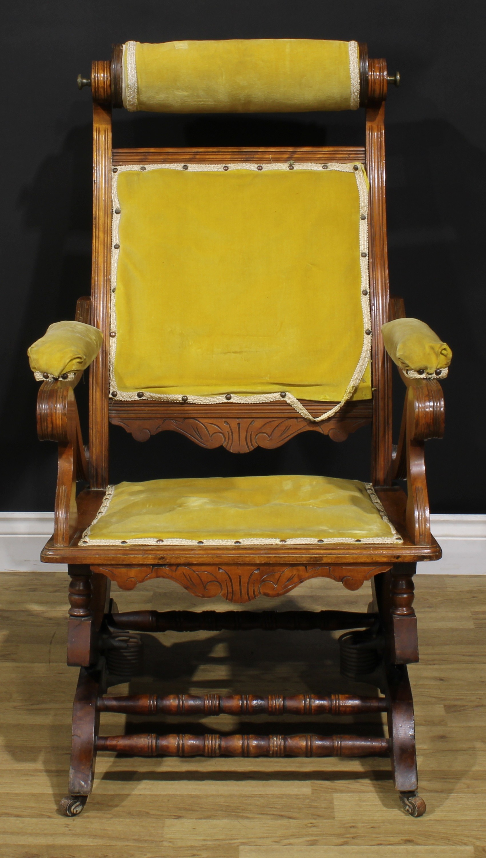 An unusual 19th century American walnut rocking chair, adjustable headrest, shaped arms, reeded