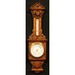 A late Victorian oak barometer, 18.5cm circular register inscribed FINNIGANS LTD, MANCHESTER, the