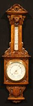 A late Victorian oak barometer, 18.5cm circular register inscribed FINNIGANS LTD, MANCHESTER, the