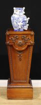 An Adam style mahogany statuary pedestal, carved and applied with bosses, leafy scrolls and bell