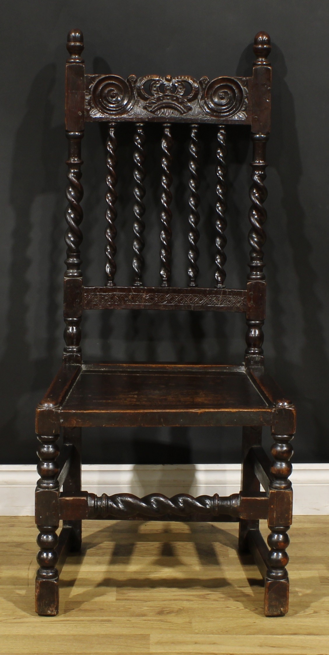 A Charles II oak side chair, curved cresting rail carved with a crown, above a row of spirally-