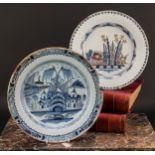 An 18th century English Delft charger, painted in underglaze blue with chinoiserie buildings,