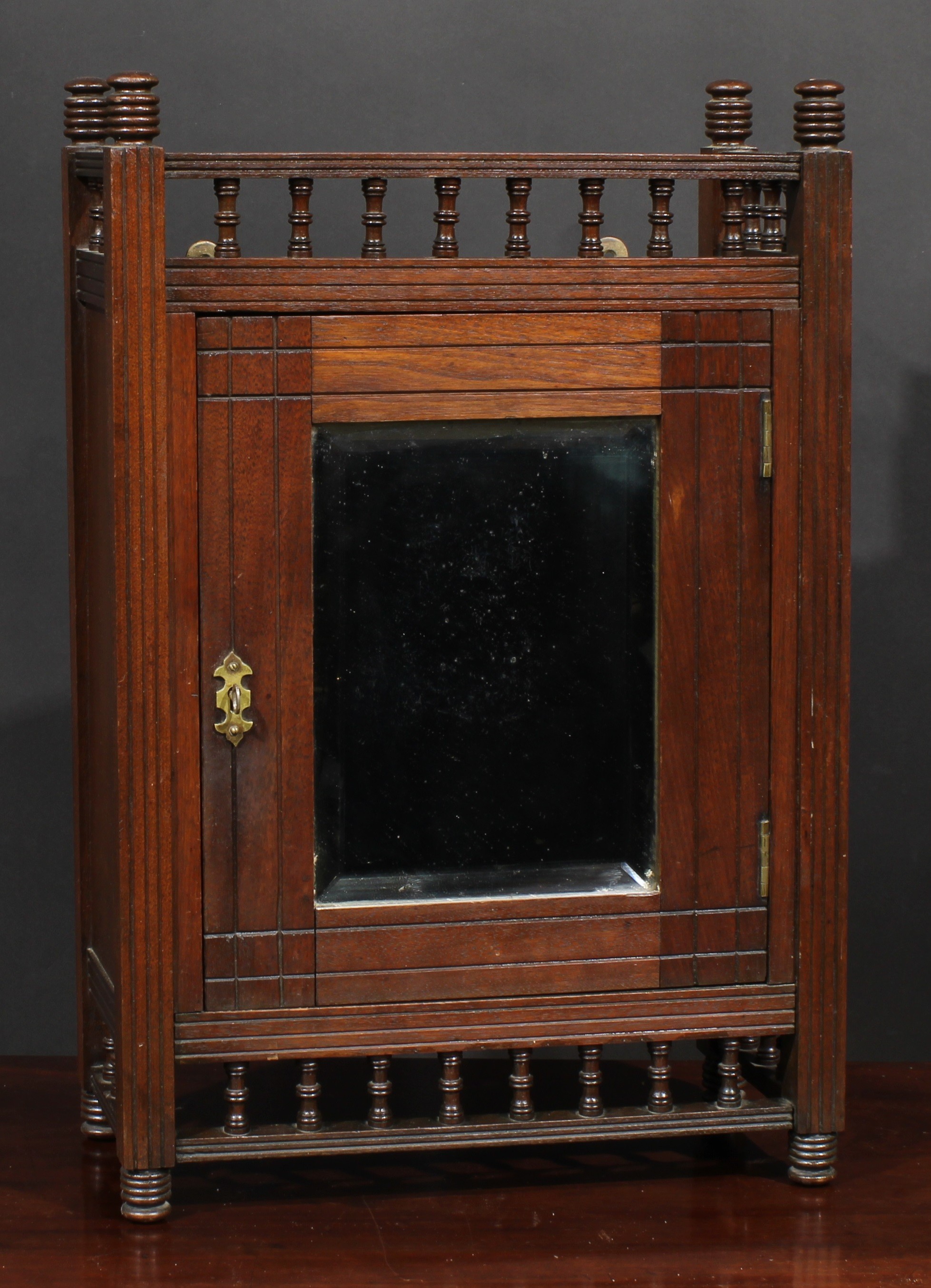 A Victorian Aesthetic Movement wall cabinet, baluster spindle galleries, the rectangular door with