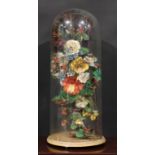 A large Victorian glass dome, enclosing an arrangement of faux flowers, grasses and leaves, in a