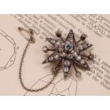 A diamond radiating starburst brooch, set with old cut stones, the central stone a faceted