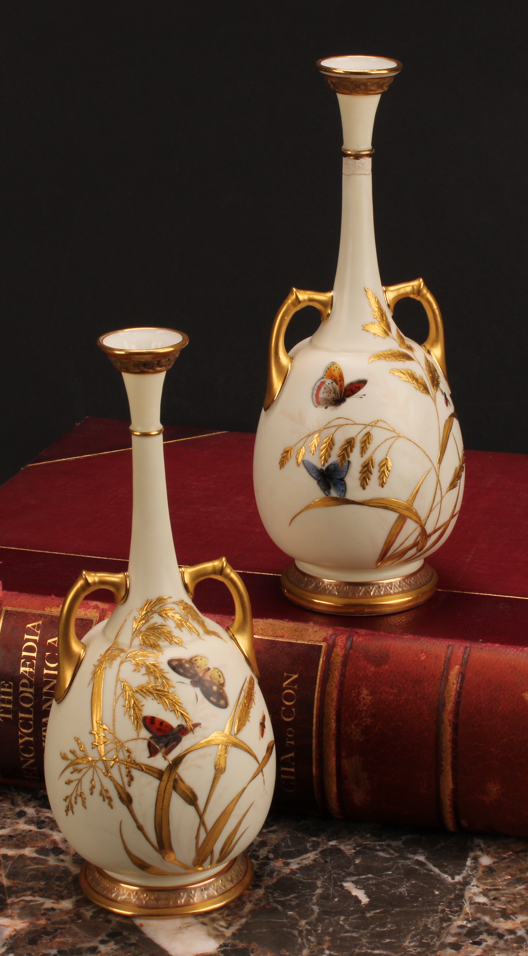 A pair of Royal Worcester two handled bottle vases, decorated in the Aesthetic manner with