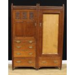 An Arts & Crafts oak compactum wardrobe, convex fluted frieze above a panel door carved with