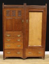 An Arts & Crafts oak compactum wardrobe, convex fluted frieze above a panel door carved with