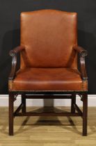 A Chippendale Revival mahogany Gainsborough armchair, stuffed-over leather upholstery, the hand