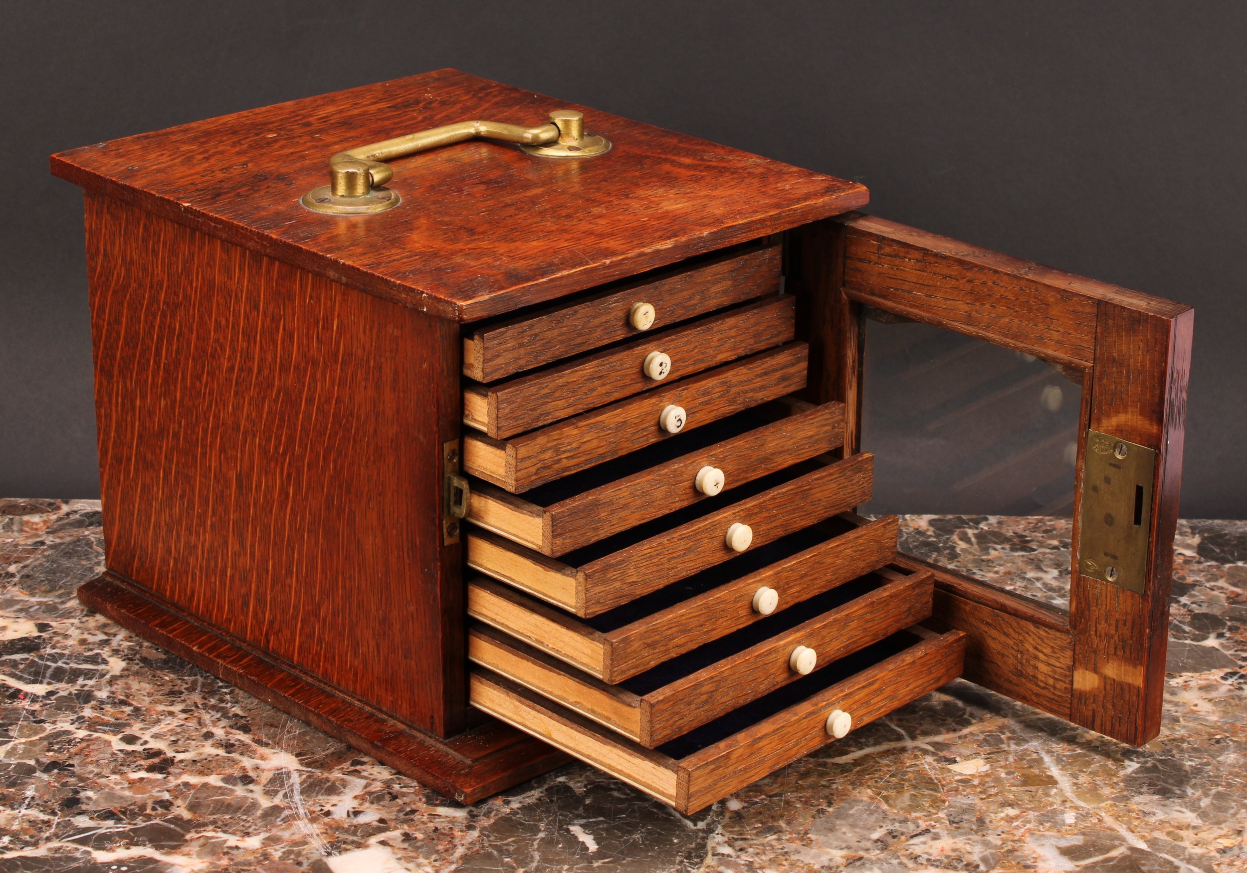 Numismatics - An Edwardian Arts and Crafts oak coin cabinet, the oversailing rectangular top with - Image 3 of 3