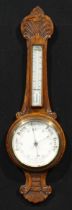 An early 20th century oak wheel barometer, 18.5cm circular register, the case carved with an