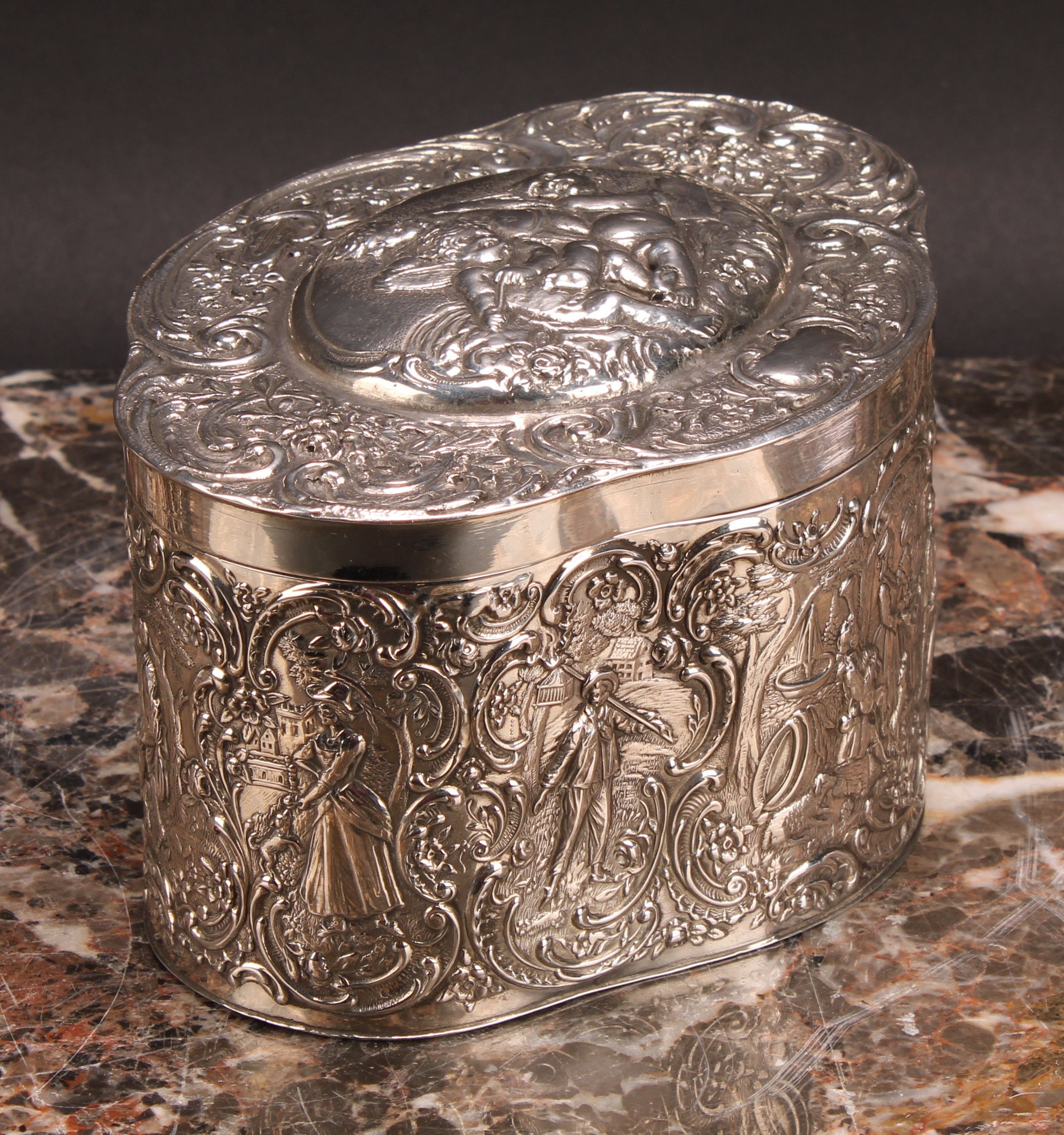 A Continental silver coloured metal oval quatrefoil biscuit box or tea caddy, repousse chased with - Image 3 of 4