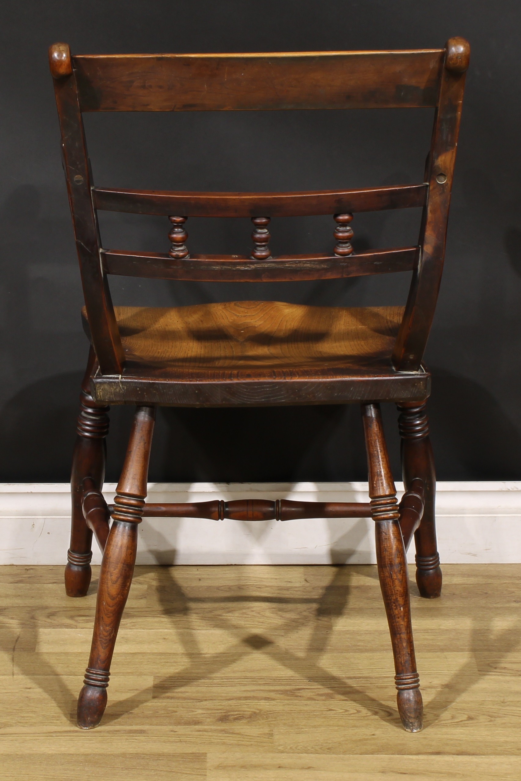 An early 19th century yew and elm elbow chair, saddle seat, turned legs, H-stretcher, 86cm high, - Image 4 of 4