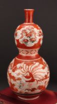 A Japanese Kutani double gourd vase, painted in the typical palette with a deity seated on a