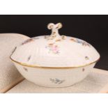 A German porcelain oval tureen and cover, moulded with flutes and diapers and decorated in