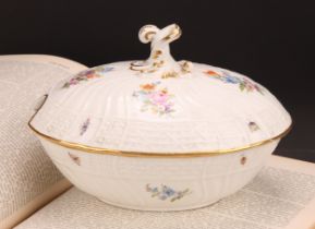 A German porcelain oval tureen and cover, moulded with flutes and diapers and decorated in