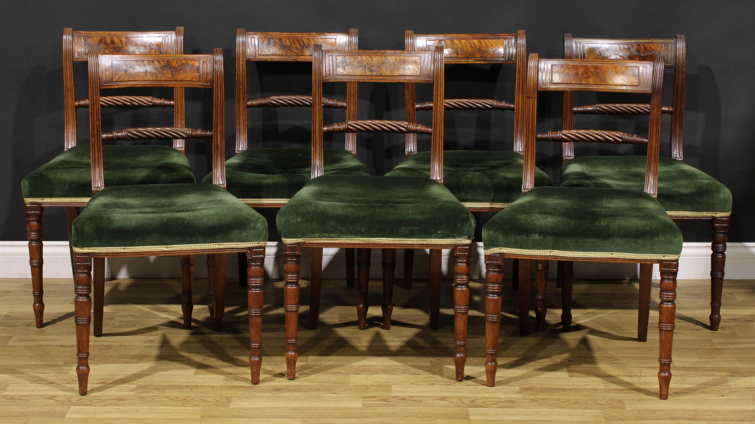 A set of seven Regency mahogany rope-twist bar-back dining chairs, curved cresting rail inlaid