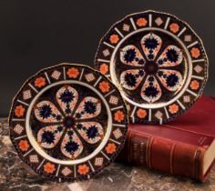 An associated pair of Royal Crown Derby Imari pattern shaped circular plates, gadrooned borders,