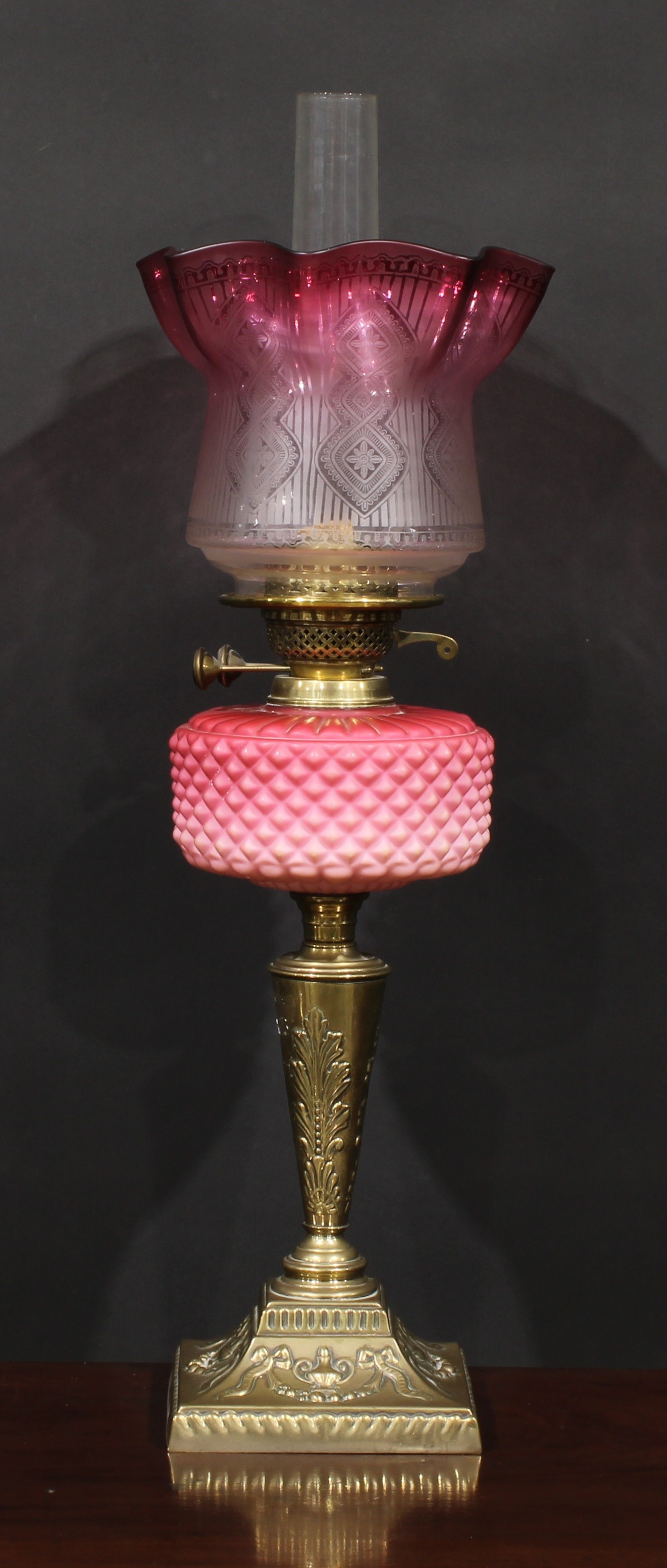 A Victorian brass and pink Vaseline glass table oil lamp, etched cranberry flashed shade, the base