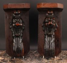 A pair of 19th century oak wall brackets, each with canted plateau above a boldly carved lion head