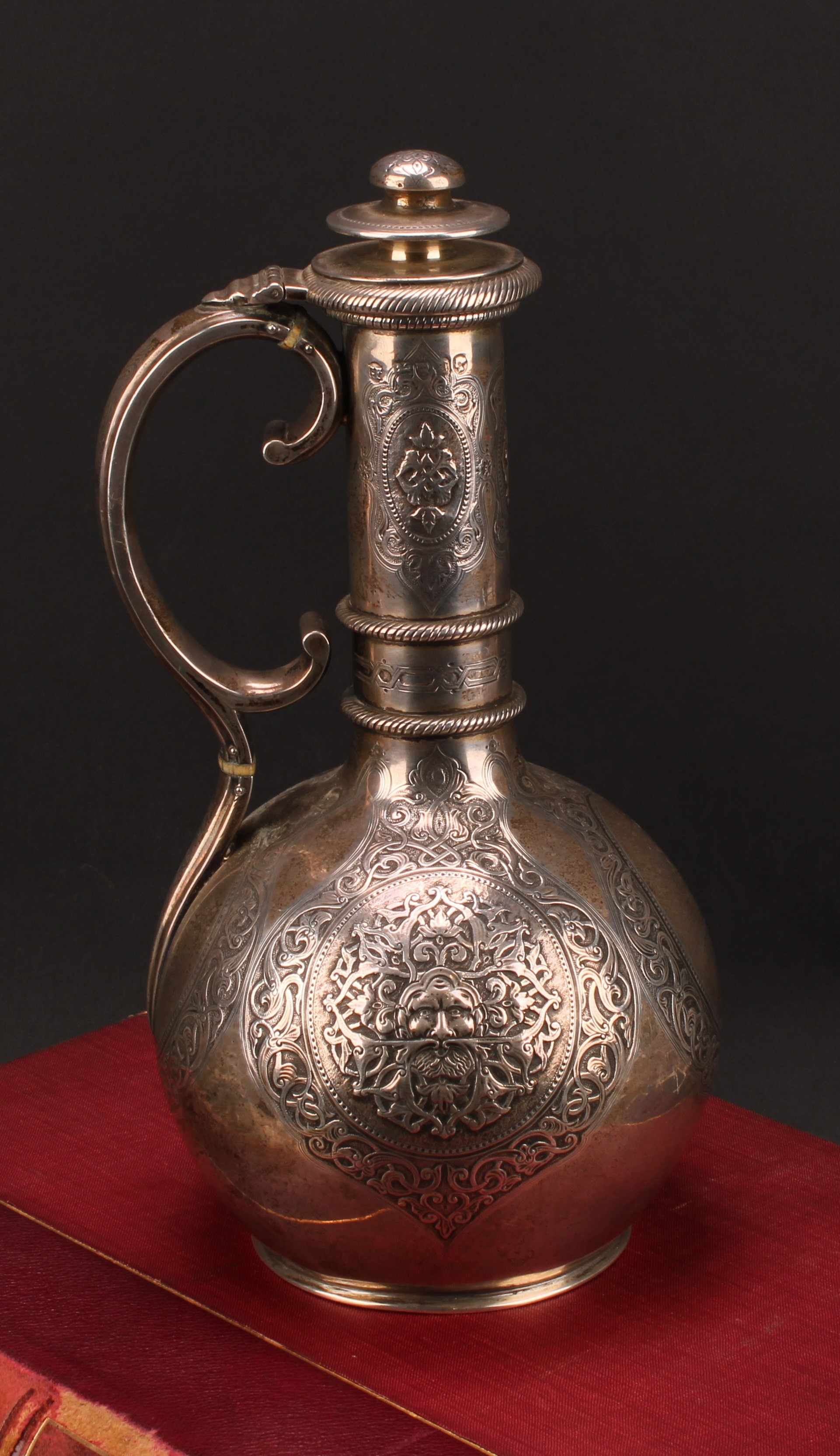 A Victorian silver globular wine ewer, chased with Green Man mask and mask of a classical lady,