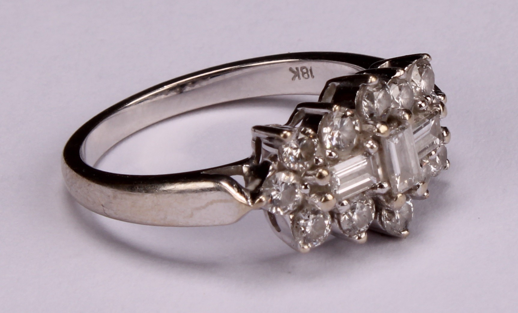 An 18k white gold diamond ring, set with three central baguette cut stones, flanked with twelve - Image 2 of 4