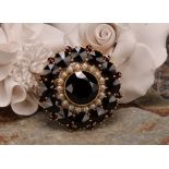 A Victorian style garnet and seed pearl target brooch, the large central round facet cut stone