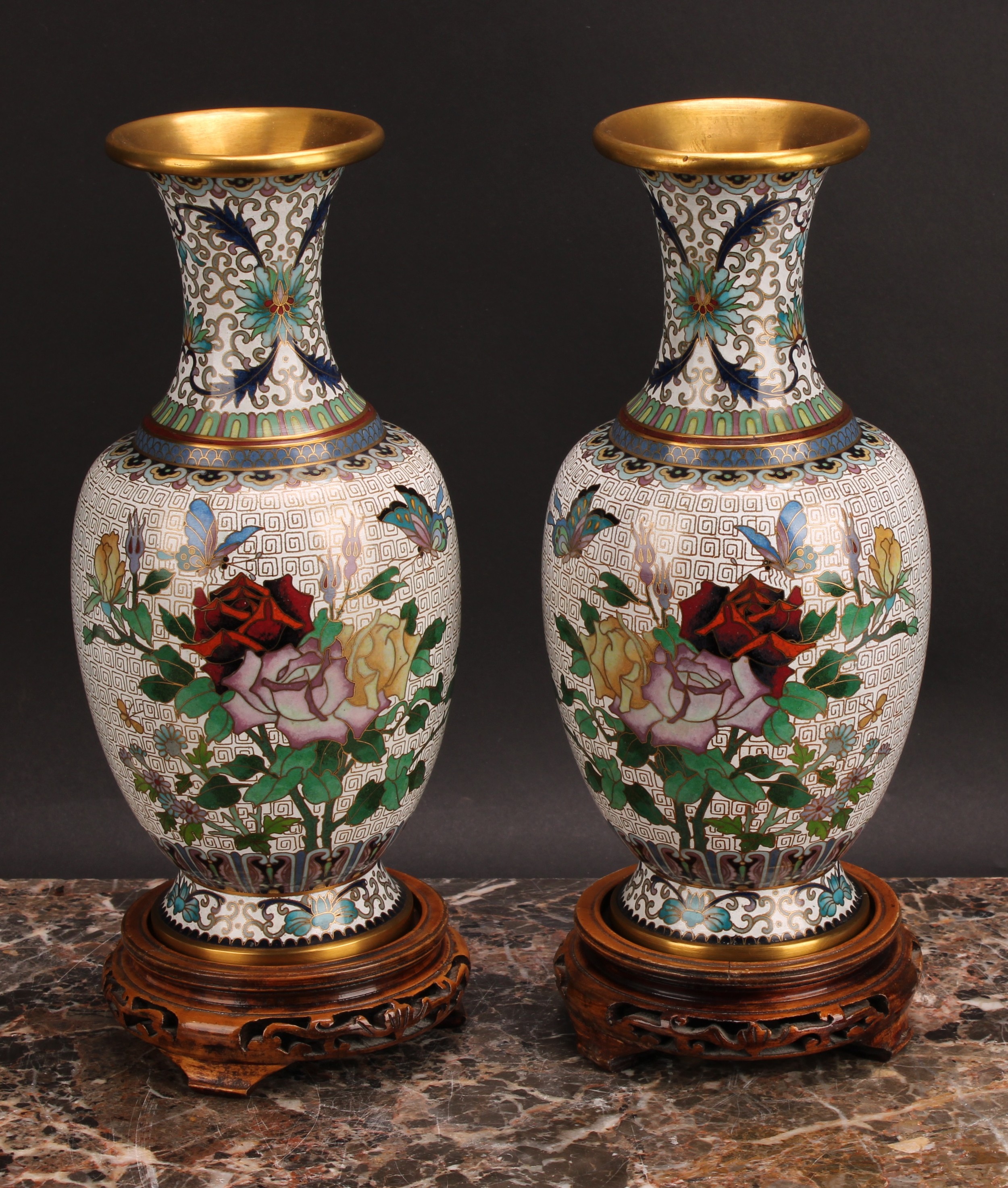 A pair of Japanese cloisonné enamel baluster vases, decorated with flowers and butterflies, hardwood