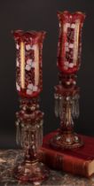 A pair of Bohemian cranberry flashed glass storm lantern candle lustres, decorated in opaque