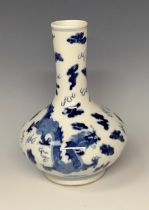 A Chinese export ware compressed ovoid bottle vase, decorated in underglaze blue with dragons and