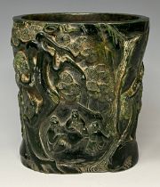 A Chinese carved green stone brush pot, possibly jade, impressed mark, 15.5cm high, 14cm wide