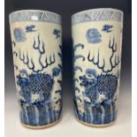 A pair of contemporary blue and white glazed circular floor standing sleeve vases, decorated in