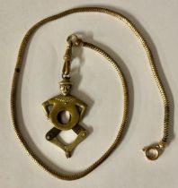 A Victorian novelty cigar cutter, as a clown, on an Albert chain, 47cm total length