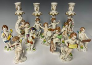 A set of eight Naples musician putti figures, each approx. 11cm, printed crown marks in blue; a